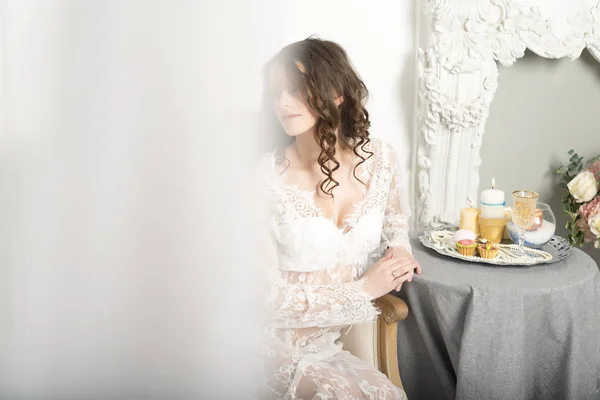 Dziewczyna w białej sukni siedzi przy stole — Zdjęcie stockowe