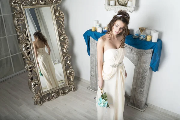 Κορίτσι σε λευκό κοντά στον καθρέφτη και το τζάκι. — Φωτογραφία Αρχείου