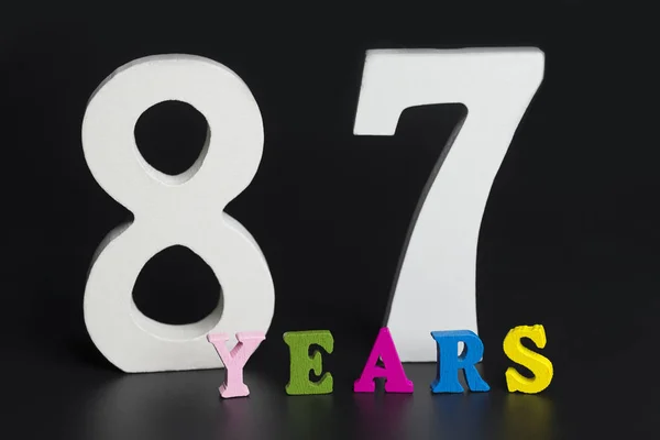 Letras e números oitenta e sete anos de idade em um fundo preto . — Fotografia de Stock