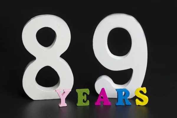 Letters en cijfers tachtig-negen jaar oud op een zwarte achtergrond. — Stockfoto