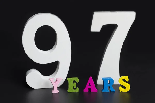 Buchstaben und Zahlen siebenundneunzig Jahre auf schwarzem Hintergrund. — Stockfoto