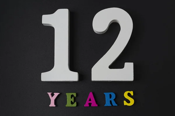 Buchstaben und Zahlen für zwölf Jahre auf schwarzem Hintergrund. — Stockfoto