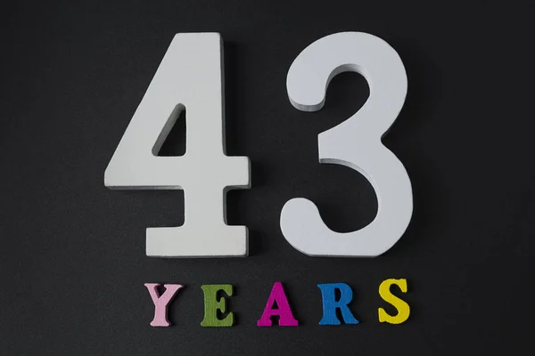 Buchstaben und Zahlen dreiundvierzig Jahre auf schwarzem Hintergrund. — Stockfoto