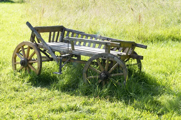 Velho vagão de madeira fica na grama . — Fotografia de Stock