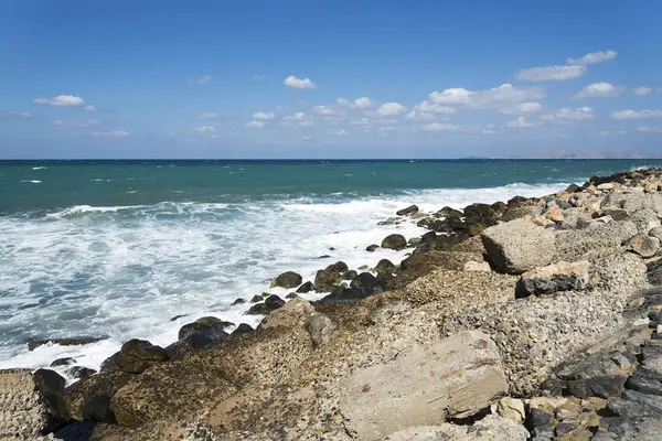 石のビーチ、砕ける波スプレーを形成します。波とビーチではね。岩に砕ける波. — ストック写真