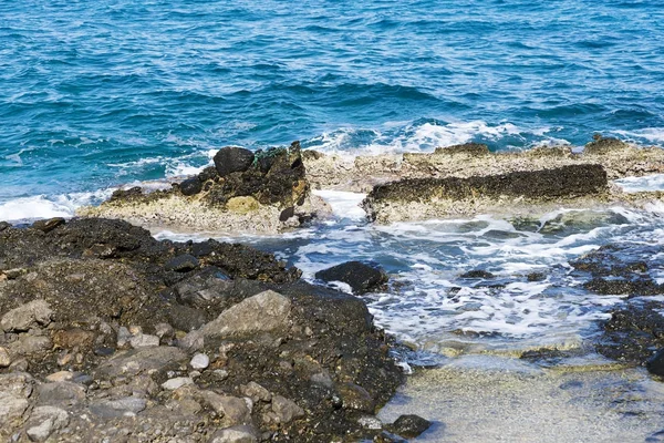 The waves breaking on a stony beach, forming a spray. Wave and splashes on beach. Waves crashing onto rocks. — Stock Photo, Image