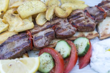 Izgara domuz biftek bir tavada, closeup görünümü sebze ve patates kızartması ile.