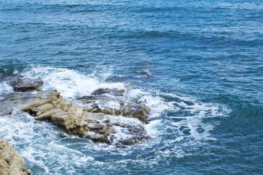 Bir sprey şekillendirme Taşlı bir kumsalda kırma dalgalar. Dalga ve su sıçramalarına sahilde. Dalgalar kayalar üzerine çökmesini.