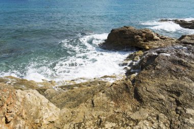 Bir sprey şekillendirme Taşlı bir kumsalda kırma dalgalar. Dalga ve su sıçramalarına sahilde. Dalgalar kayalar üzerine çökmesini.