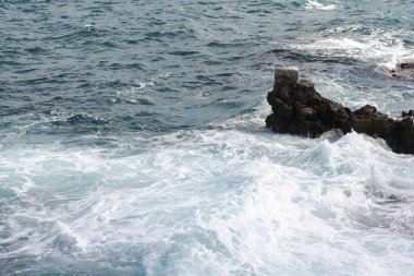 Bir sprey şekillendirme Taşlı bir kumsalda kırma dalgalar. Dalga ve su sıçramalarına sahilde. Dalgalar kayalar üzerine çökmesini.