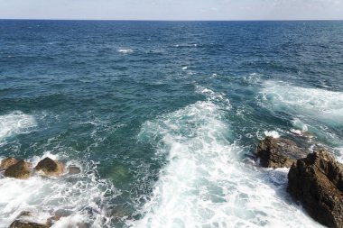 Bir sprey şekillendirme Taşlı bir kumsalda kırma dalgalar. Dalga ve su sıçramalarına sahilde. Dalgalar kayalar üzerine çökmesini.