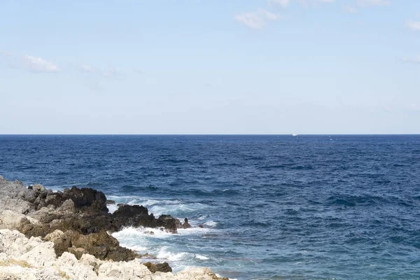 Bir sprey şekillendirme Taşlı bir kumsalda kırma dalgalar. Dalga ve su sıçramalarına sahilde. Dalgalar kayalar üzerine çökmesini.