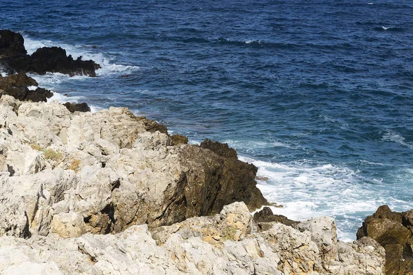 Bir sprey şekillendirme Taşlı bir kumsalda kırma dalgalar. Dalga ve su sıçramalarına sahilde. Dalgalar kayalar üzerine çökmesini.