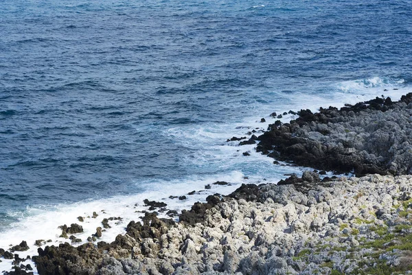 Vlny narážely na kamenité pláži, tvořící sprej. Vlna a šplouchá na pláži. Velké vlny na skály. — Stock fotografie