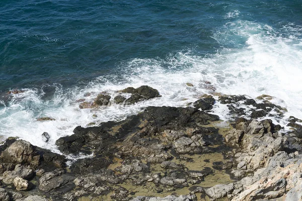 The waves breaking on a stony beach, forming a spray. Wave and splashes on beach. Waves crashing onto rocks. — Stock Photo, Image