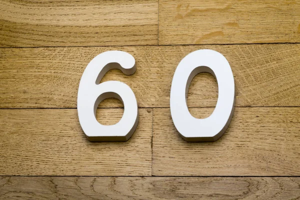 Cijfers zestig op de houten, parketvloer. — Stockfoto