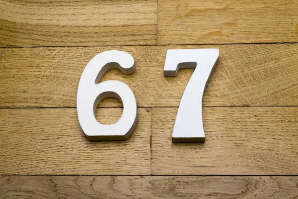 Siffror sextiosju på trä, parkett golv. — Stockfoto