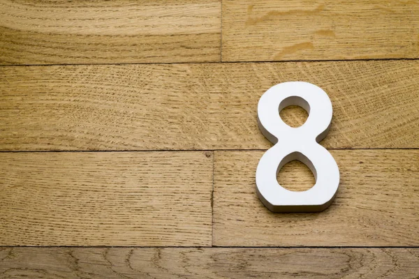 Цифры восемь на деревянном паркетном полу . — стоковое фото