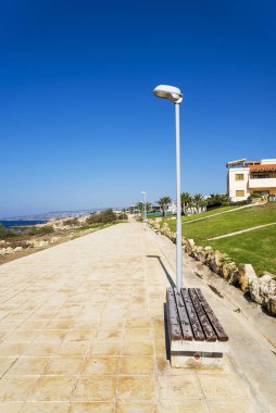 Akdeniz kıyısında otellerle dolu bir bankta..