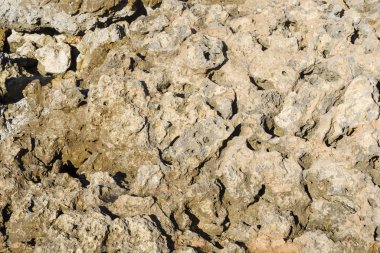 Çatlaklarla kaplı bej duvarın dokusu
