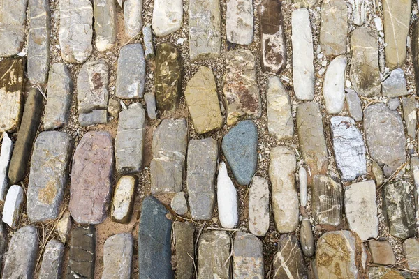 Piedras multicolores en el suelo. Diferentes formas y tamaños — Foto de Stock