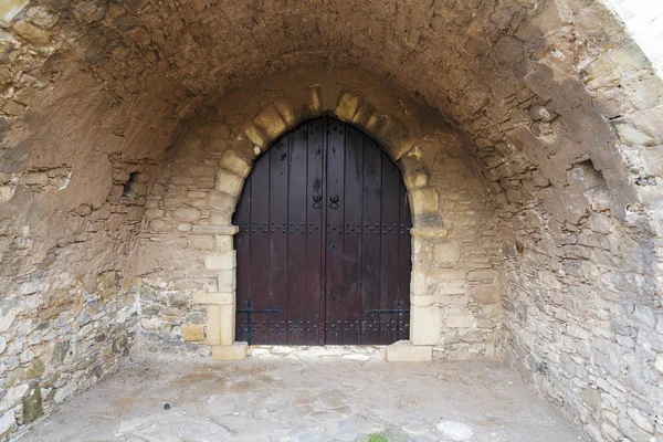 Una puerta de madera cerrada a un edificio de piedra . — Foto de Stock