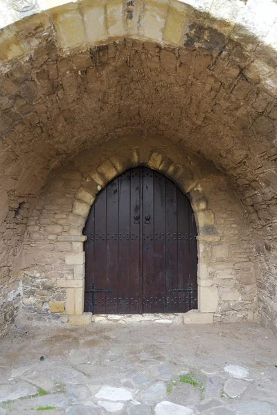 Una puerta de madera cerrada a un edificio de piedra . — Foto de Stock