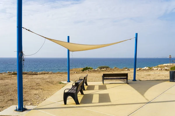 Paphos yakınlarındaki Kıbrıs adasında denize bakan banklar. — Stok fotoğraf