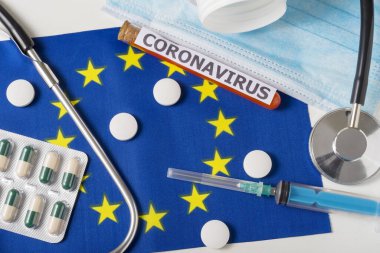 Coronavirus, ncov konsepti. Üst düzey koruyucu maske, steteskop, şırınga, Avrupa bayrağında haplar. Yeni bir Çin Coronavirüsü salgını.