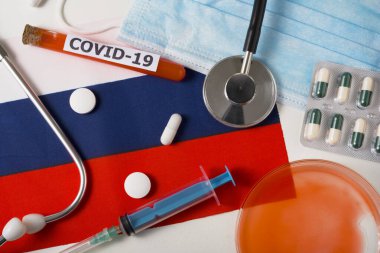 Coronavirus, Covid-19 konsepti. Koruyucu bir maske, steteskop, şırınga, Rusya bayrağında haplar. Yeni bir Çin Coronavirüsü salgını.