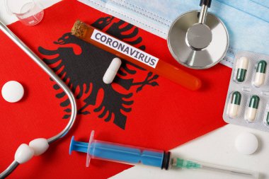 Coronavirus, ncov konsepti. Üst düzey koruyucu solunum maskesi, steteskop, şırınga, Arnavutluk bayrağında haplar. Yeni bir Çin Coronavirüsü salgını.
