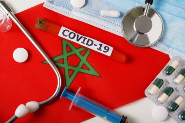 Coronavirus, Covid-19 konsepti. Üst düzey koruyucu solunum maskesi, steteskop, şırınga, Fas bayrağında haplar. Yeni bir Çin Coronavirüsü salgını.