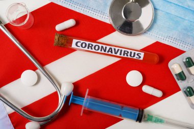 Coronavirus, NCoV konsepti. Üst düzey koruyucu solunum maskesi, steteskop, şırınga, Avusturya bayrağında tabletler. Yeni bir Çin Coronavirüsü salgını.