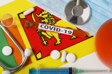 Coronavirus, COVid-19 konsepti. Üst düzey koruyucu solunum maskesi, steteskop, şırınga, Sri Lanka bayrağında tabletler. Yeni bir Çin Coronavirüsü salgını.