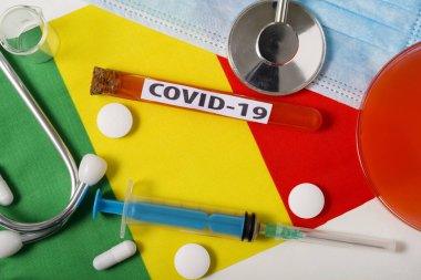 Coronavirus, COVid-19 konsepti. Üst düzey koruyucu solunum maskesi, steteskop, şırınga, Mali bayrağında tabletler. Yeni bir Çin Coronavirüsü salgını.
