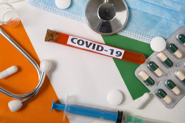 Coronavirus, COVid-19 konsepti. Üst düzey koruyucu solunum maskesi, steteskop, şırınga, fildişi rengi sahilde haplar. Yeni bir Çin Coronavirüsü salgını.