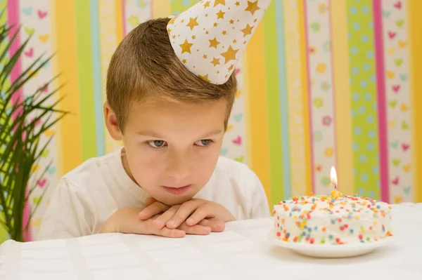 holiday, birthday of a teenager school boy, a child of 10 years old on the table a cake with a candle and a gift, the theme of the holiday without friends in quarantine