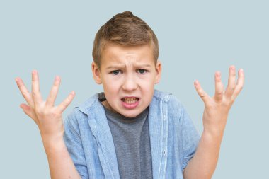 Portreci çocuk 10 yaşında. Mesajlaşma yeri olan izole edilmiş mavi bir arka planda şaşkınlığını dile getiriyor.