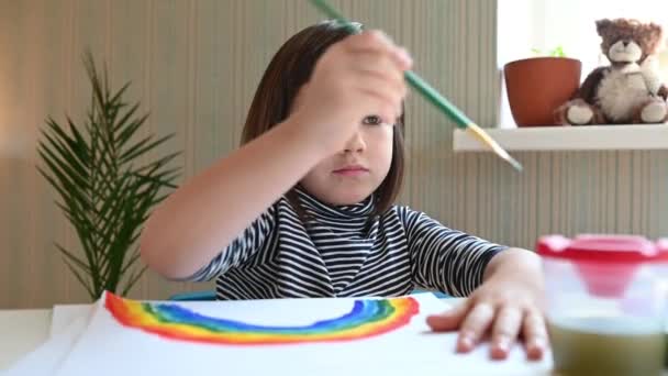 7歳の少女がパンデミックの終わりの象徴として虹を描き — ストック動画