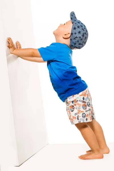 Blonder Junge schiebt weißen Speck an die Wand — Stockfoto