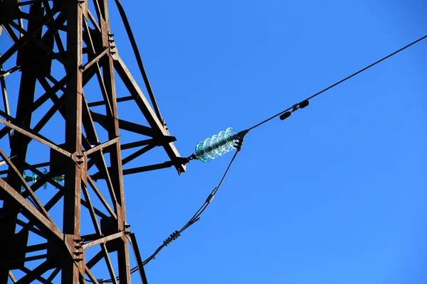 青い空に対して懸濁絶縁体と架空送電線のパイロンの一部 — ストック写真