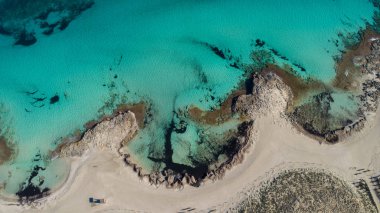 Formentera sahilinde kayalar, turkuaz ve kristal deniz var.