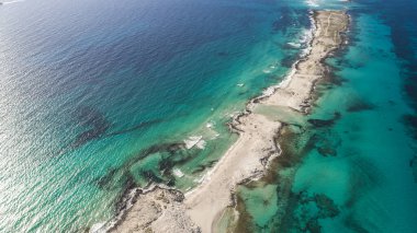 Akdeniz 'in beyaz kumsalında, havada insansız hava aracıyla görülen inanılmaz turkuaz bir deniz var.