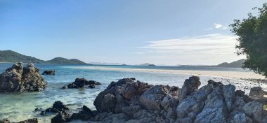 Turkuaz su, kayalar ve denizde eriyen beyaz kumdan oluşan dar bir şerit manzarası. Palawan Adası. Filipinler.