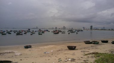 Da nang, Vietnam 'da düzinelerce balıkçı teknesi. Gri gökyüzü, arka planda şehir.