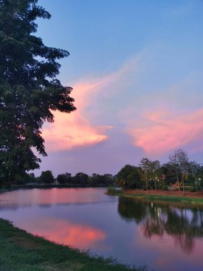 Şafak, pembe gökyüzü ve bir gölün yansıması, Kuzey Tayland