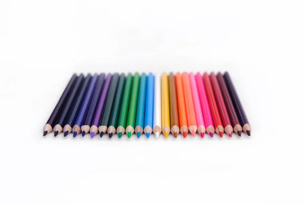 Set of colored pencils arranged in a row horizontally on a white background. selective focus — Stockfoto