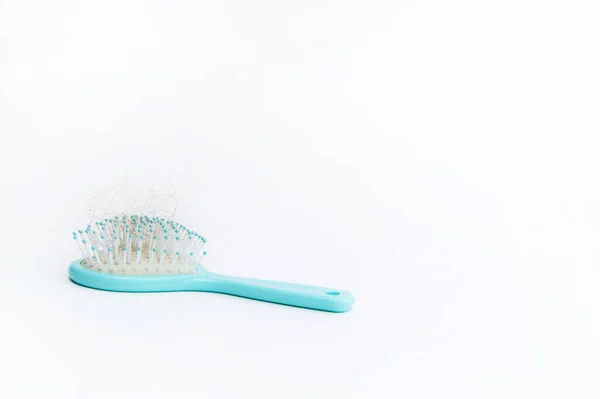 Turquoise color baby comb on a white background. Lost hair remaining in the comb — Stock Photo, Image