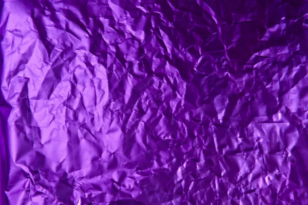 Background crumpled foil paper of violet color