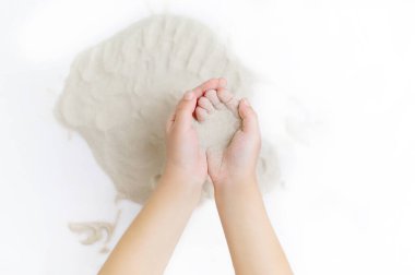 Çocukların elleri kum havuzunda doğal kuru kumu çizmek için tutuyor.